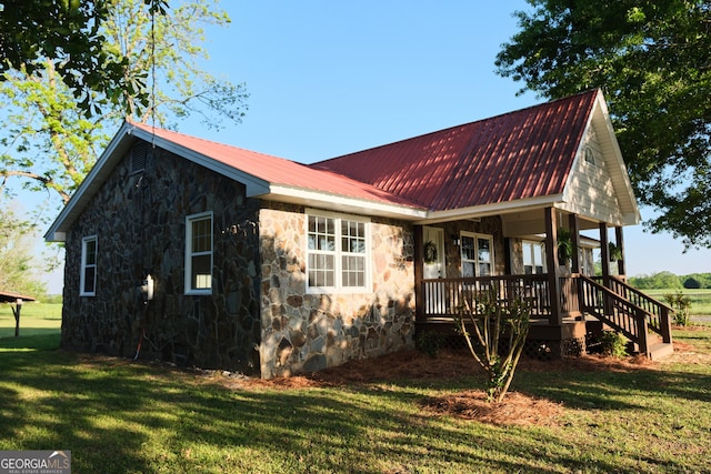 243 College St, Yatesville, GA 31097 - view of side of property featuring stone siding, a porch, a lawn, and metal roof