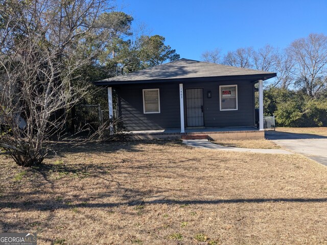 view of front of home featuring covered porch and a front yard