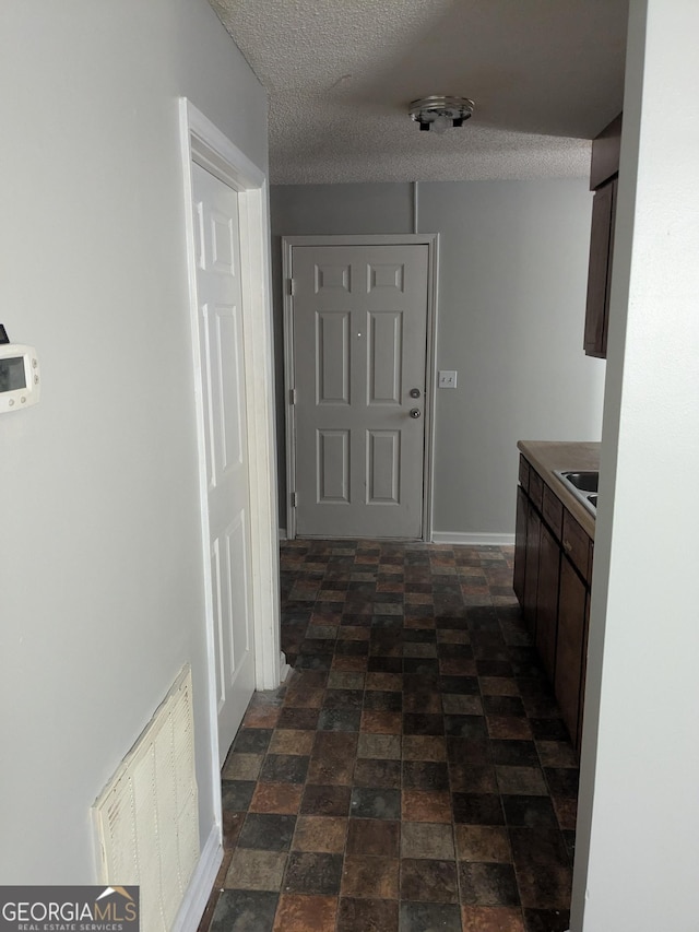 hallway featuring sink and a textured ceiling