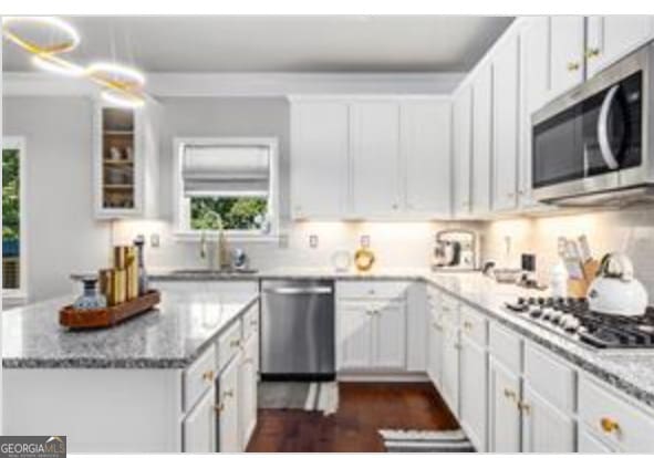 kitchen featuring light stone countertops, appliances with stainless steel finishes, sink, and white cabinets