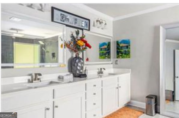 bathroom with ornamental molding and sink