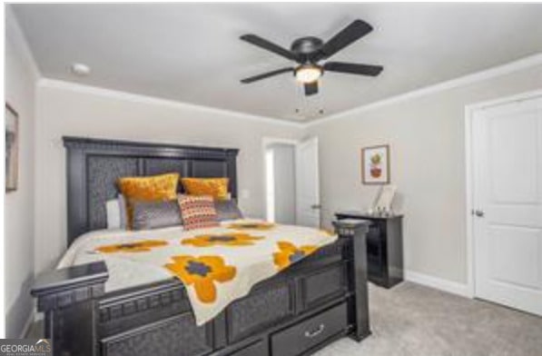 bedroom featuring ornamental molding, light colored carpet, and ceiling fan