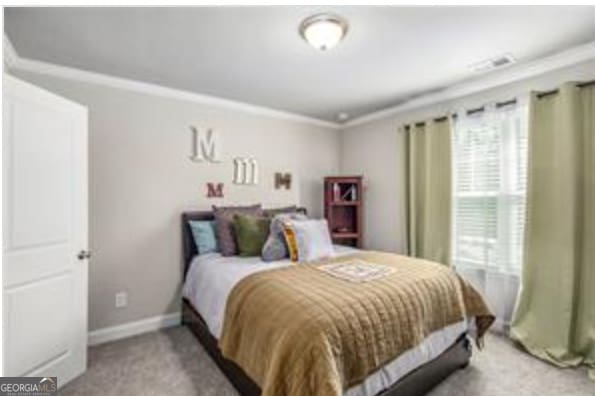 bedroom featuring crown molding and carpet floors