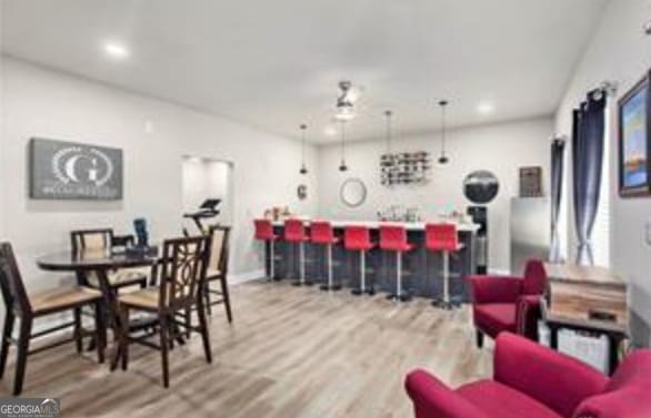 dining space featuring wood-type flooring and bar