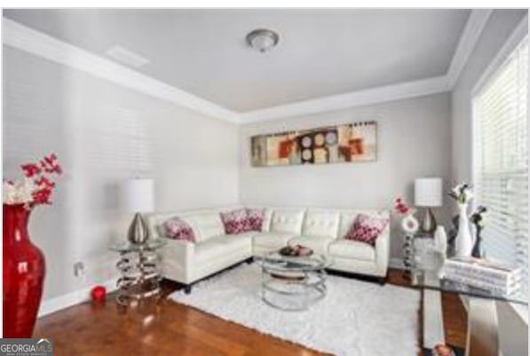 living room featuring hardwood / wood-style floors and crown molding