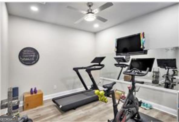 workout room featuring light hardwood / wood-style flooring and ceiling fan