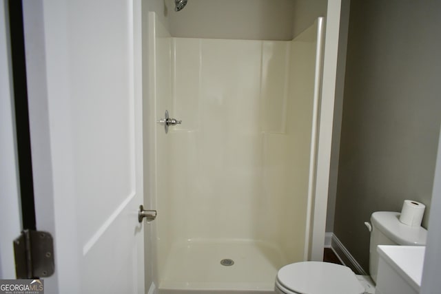 bathroom featuring a shower and toilet