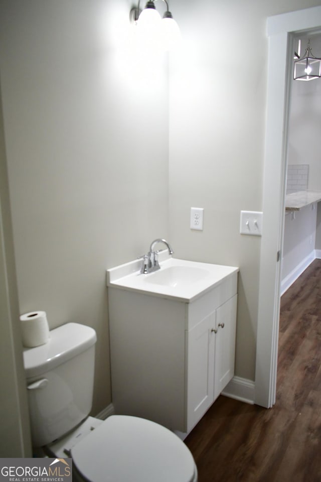 bathroom featuring hardwood / wood-style flooring, vanity, and toilet