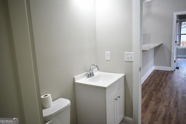 bathroom featuring vanity, hardwood / wood-style flooring, and toilet