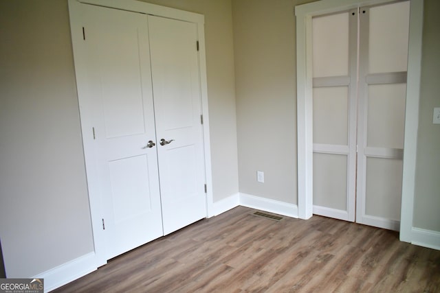 unfurnished bedroom featuring hardwood / wood-style flooring