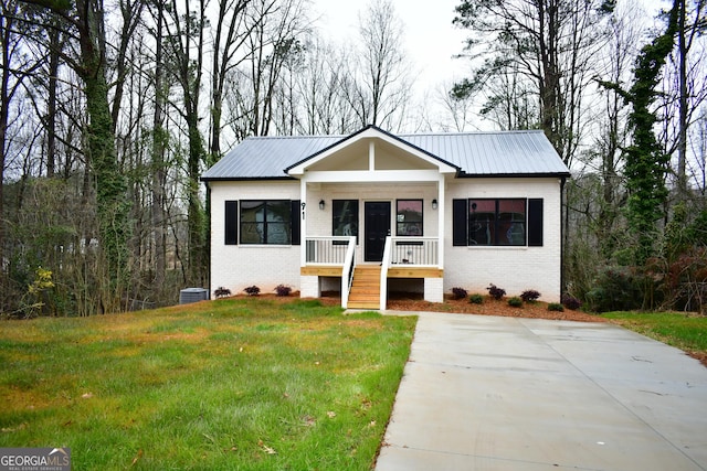 view of front facade with cooling unit and a front lawn