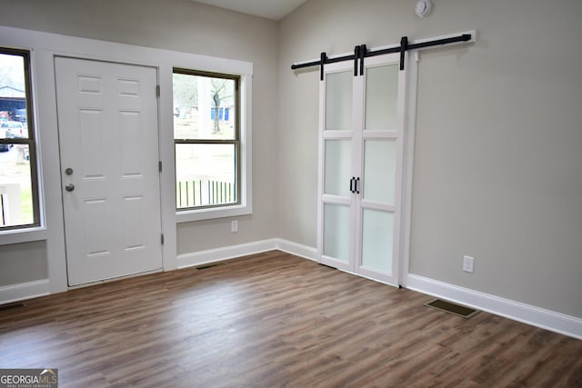 entrance foyer featuring dark hardwood / wood-style flooring and a barn door