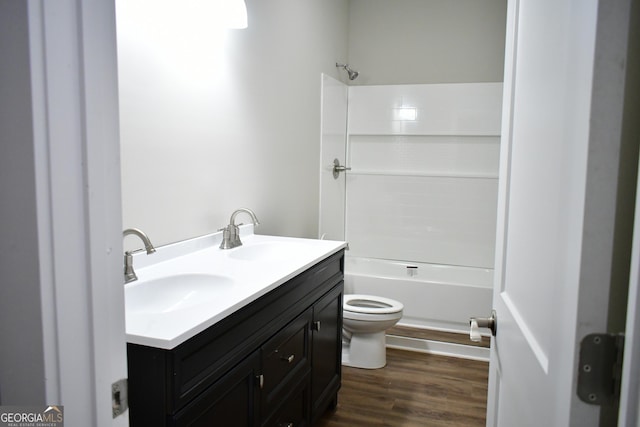 full bathroom featuring vanity, toilet,  shower combination, and wood-type flooring