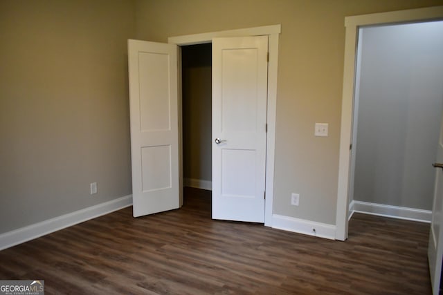 unfurnished bedroom with dark wood-type flooring