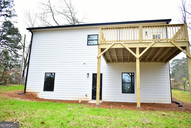 back of house with a wooden deck and a yard