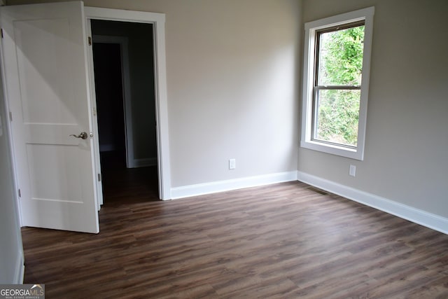 unfurnished room featuring dark hardwood / wood-style floors and a wealth of natural light