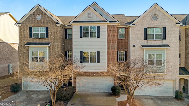 townhome / multi-family property featuring concrete driveway, brick siding, board and batten siding, and an attached garage