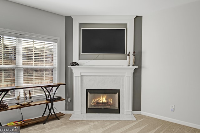 interior details with carpet floors, baseboards, and a tiled fireplace