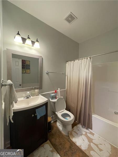 full bathroom with toilet, vanity, shower / bathtub combination with curtain, and tile patterned flooring