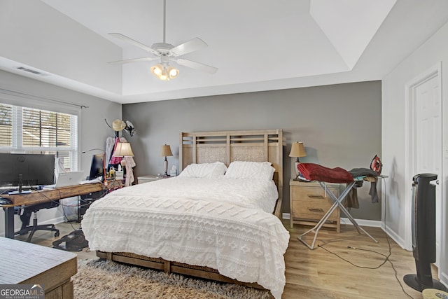 bedroom featuring light wood-type flooring, visible vents, baseboards, and a ceiling fan