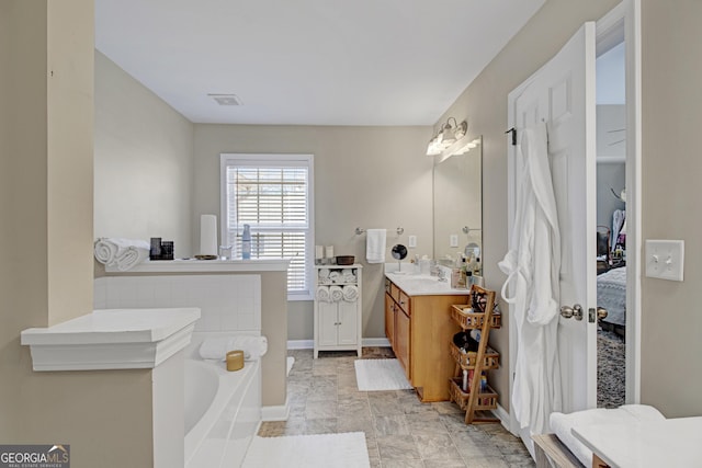 full bathroom with baseboards, visible vents, a bath, and vanity