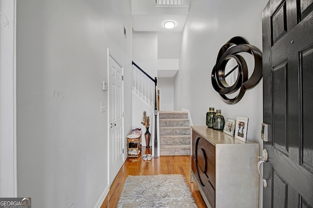 corridor featuring light wood-style floors and stairs