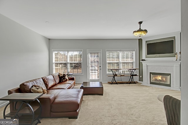 living room with a healthy amount of sunlight, carpet flooring, a fireplace, and baseboards