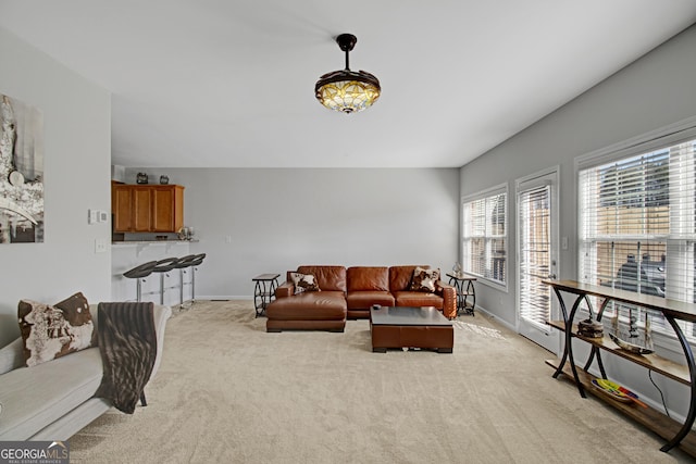 living room with baseboards and light colored carpet