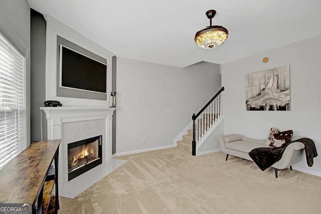 interior space featuring baseboards, stairway, and a tile fireplace