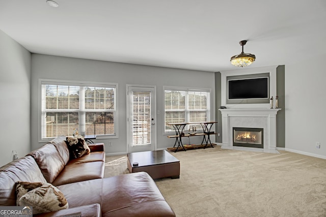 living room with a premium fireplace, baseboards, and carpet flooring