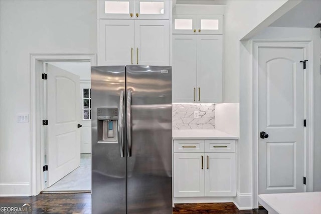 kitchen featuring stainless steel refrigerator with ice dispenser, white cabinetry, hardwood / wood-style floors, and tasteful backsplash