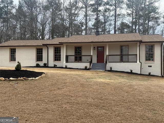 ranch-style home featuring covered porch and a front yard