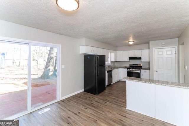 kitchen featuring appliances with stainless steel finishes, dark hardwood / wood-style floors, light stone countertops, a textured ceiling, and white cabinets