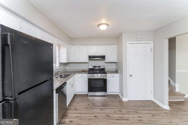 kitchen with sink, stainless steel appliances, a textured ceiling, white cabinets, and light wood-type flooring