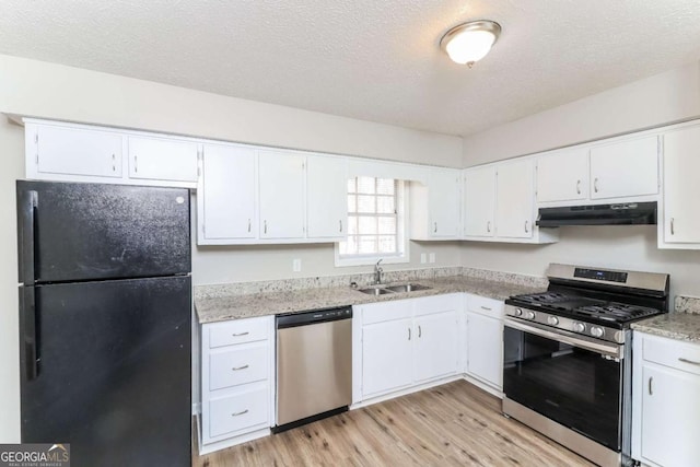 kitchen featuring sink, light wood-type flooring, white cabinets, stainless steel appliances, and a textured ceiling