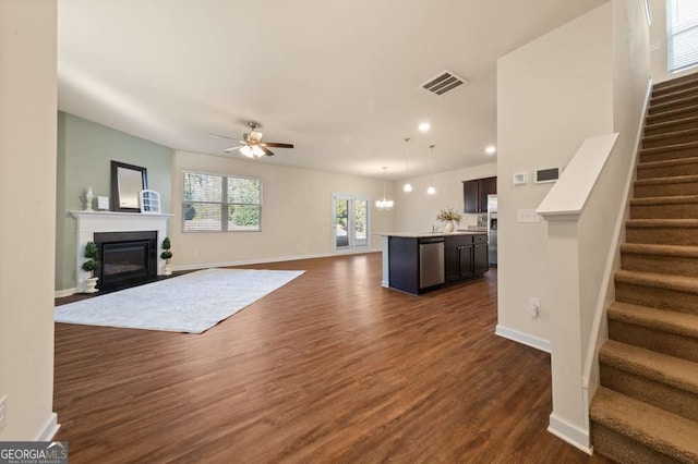 unfurnished living room with dark hardwood / wood-style floors and ceiling fan