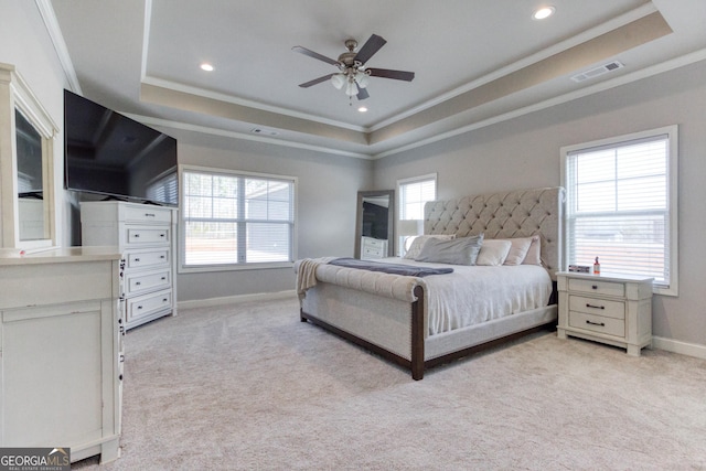 bedroom featuring light carpet, ornamental molding, a raised ceiling, and ceiling fan