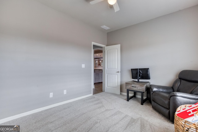 living area with light colored carpet and ceiling fan