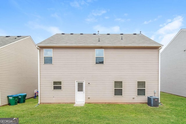 rear view of property with cooling unit and a yard