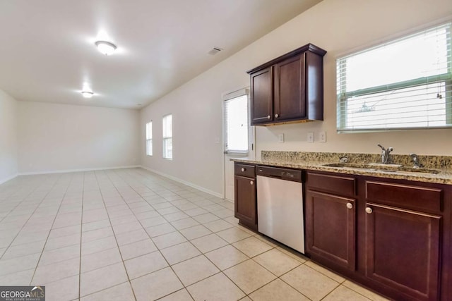 kitchen with dishwasher, sink, light tile patterned flooring, and light stone counters