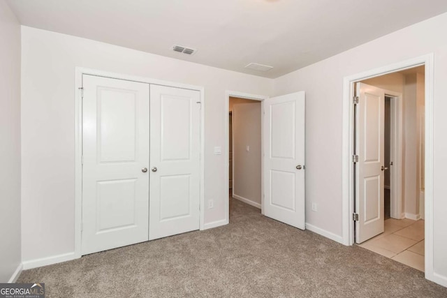 unfurnished bedroom with a closet and light carpet