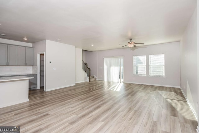 unfurnished living room with ceiling fan and light hardwood / wood-style floors