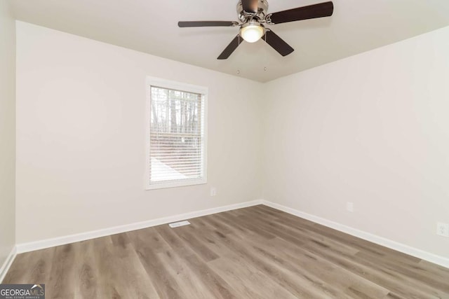 spare room featuring wood-type flooring and ceiling fan