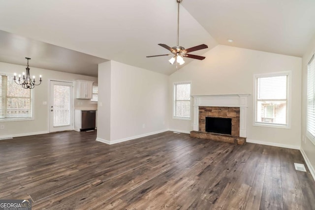 unfurnished living room with a stone fireplace, dark wood-type flooring, ceiling fan with notable chandelier, and lofted ceiling