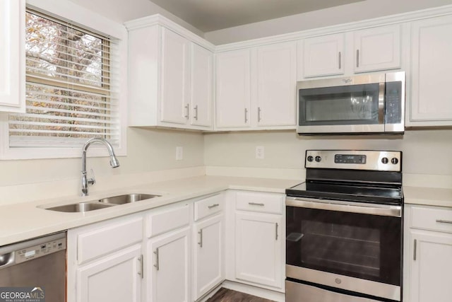 kitchen with appliances with stainless steel finishes, sink, and white cabinets