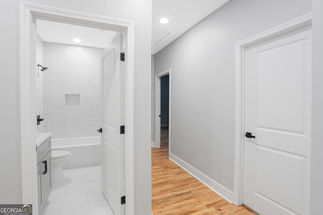 full bathroom featuring vanity, tiled shower / bath, and toilet