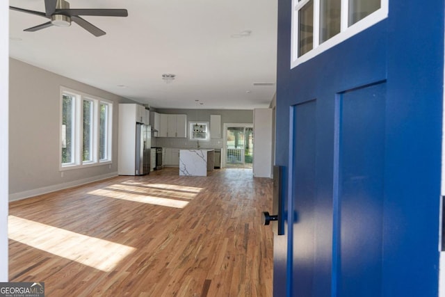 unfurnished living room featuring hardwood / wood-style floors and ceiling fan