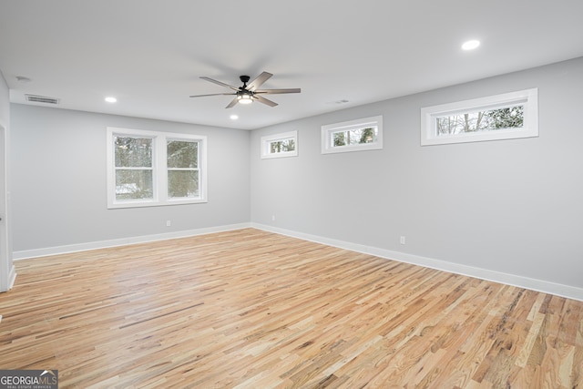 empty room featuring ceiling fan, a healthy amount of sunlight, and light hardwood / wood-style floors