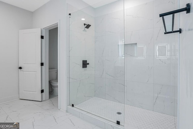 bathroom featuring toilet and a tile shower