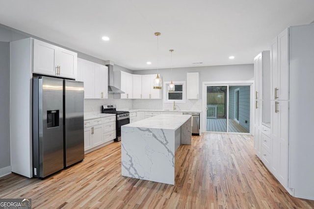 kitchen with pendant lighting, white cabinetry, stainless steel appliances, and a center island